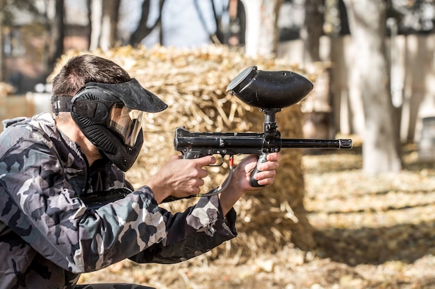 A man with a gun playing paintball.