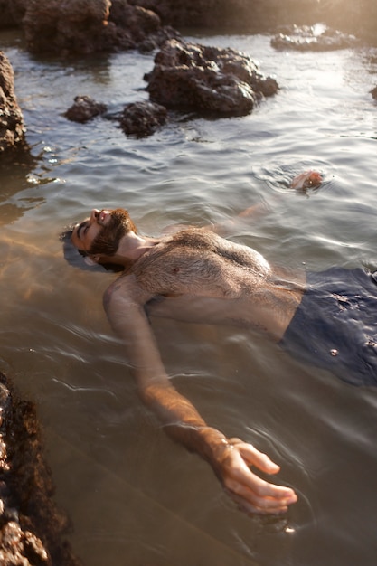 Free photo man with hairy chest at seaside