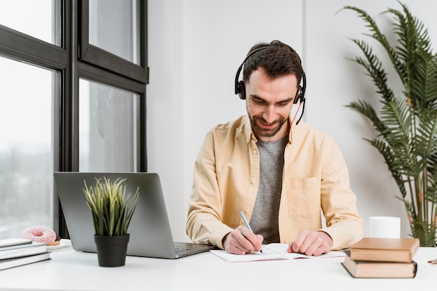 Man with headset having video call on laptop