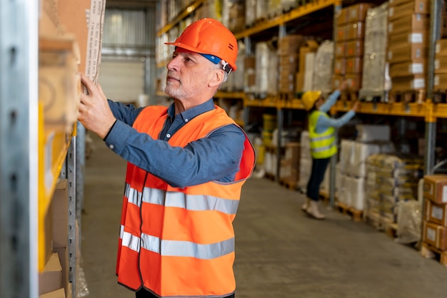 Free photo man with helmet working in warehouse