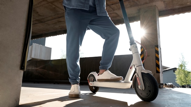 Free photo man with his scooter in a parking lot indoors