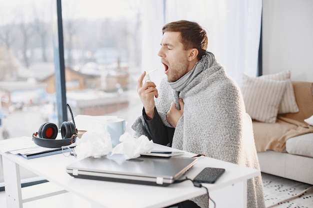 Free photo man with a laptop is suffering with cough and feeling bad. businessman at home.