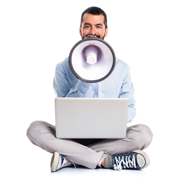 Free photo man with laptop shouting by megaphone