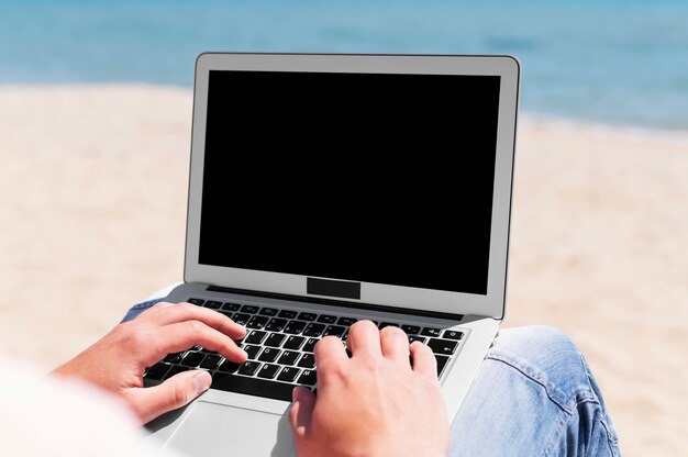 Man with laptop working at the beach