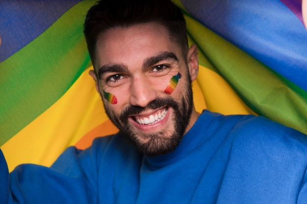 Man with LGBT rainbow on face on gay parade