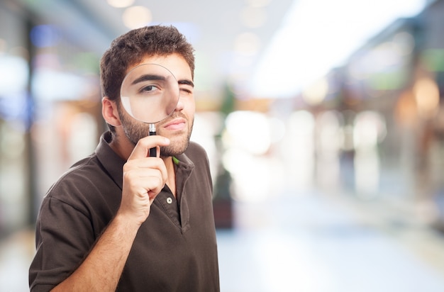 Man with a magnifying glass in a shopping center