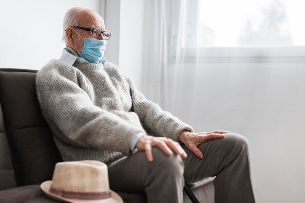 Man with medical mask sitting in a nursing home