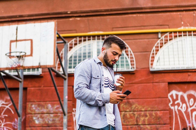 Free photo man with mobile phone drinking coffee