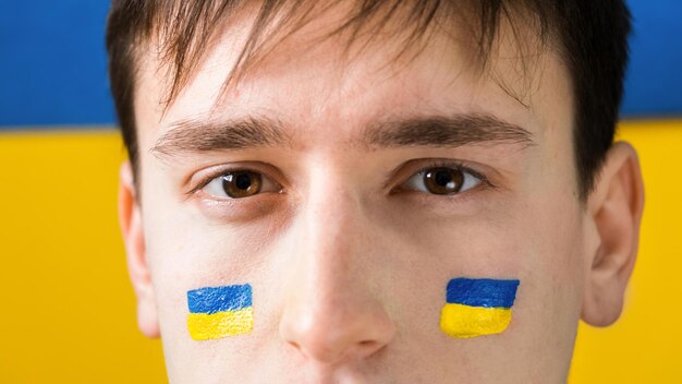 Man with national flags of Ukraine on his cheeks