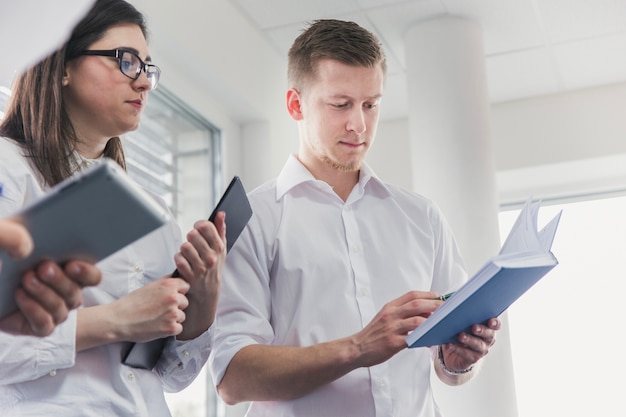 Man with notebook in front of coworkers