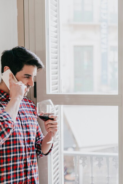 Man with phone drinking wine