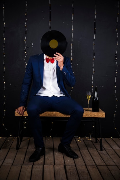 Free photo man with phonograph disk near bottle and glass