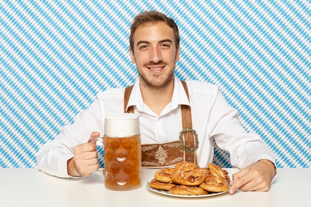 Free photo man with plate of pretzels and beer