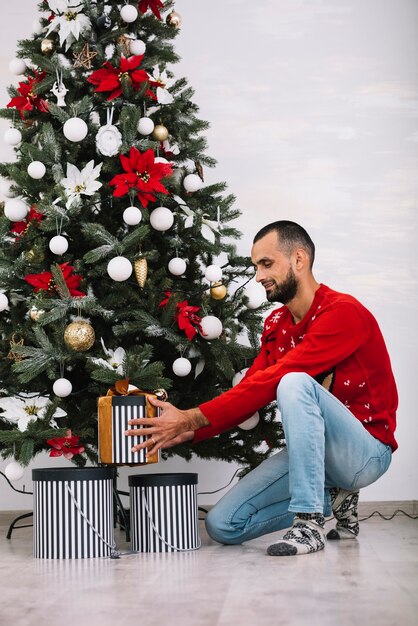 Man with present box near fir tree