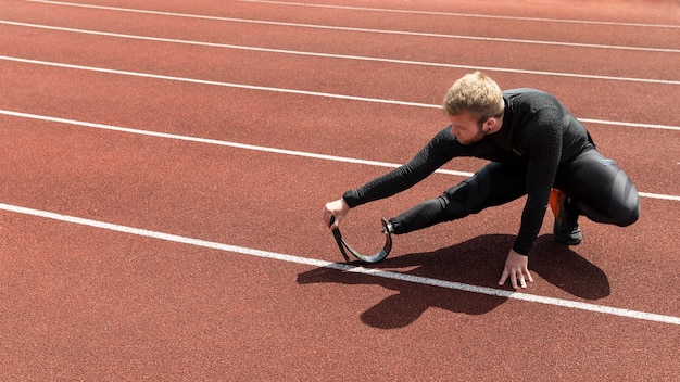 Free Photo man with prosthetic leg stretching full shot