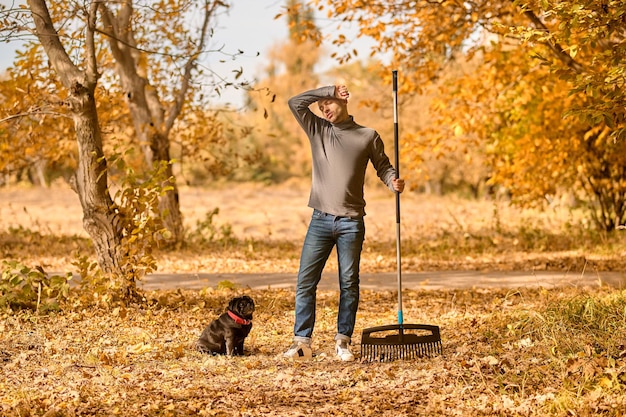 A man with a rake standing in the park