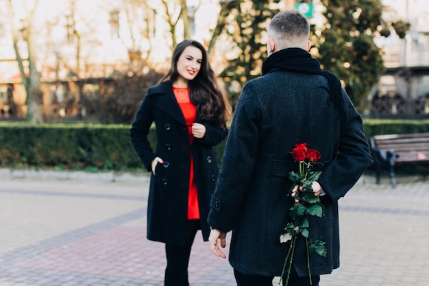 Man with roses for elegant girlfriend