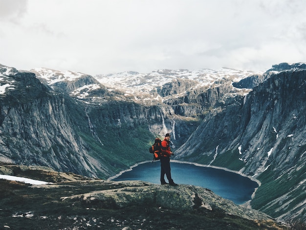 Free photo man with a rucksack admires gorgeous mountain landscape