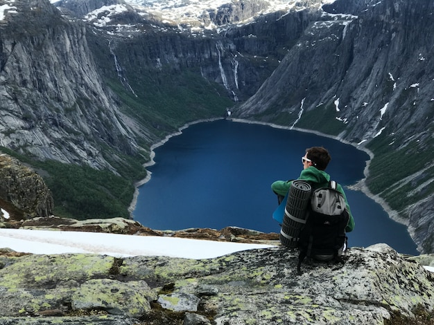 Man with a rucksack admires gorgeous mountain landscape