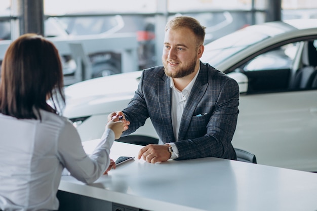 Man with sales woman in car showroom