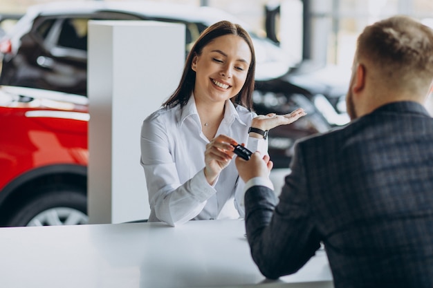 Man with sales woman in car showroom