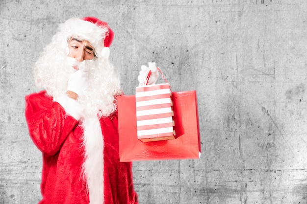 Free photo man with santa claus costume holding shopping bags