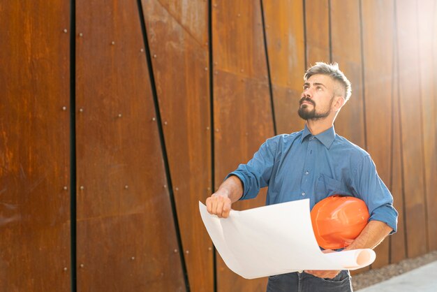 Man with schematic and helmet