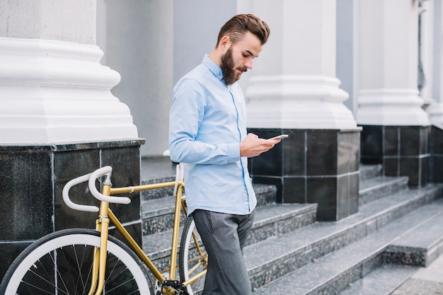 Man with smartphone standing on stairs