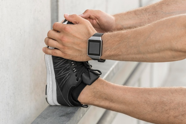 Free Photo man with smartwatch stretching outside