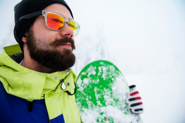 Free photo man with snowboard during winter time