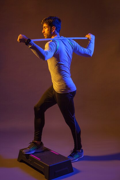 Man with stick exercising on step box