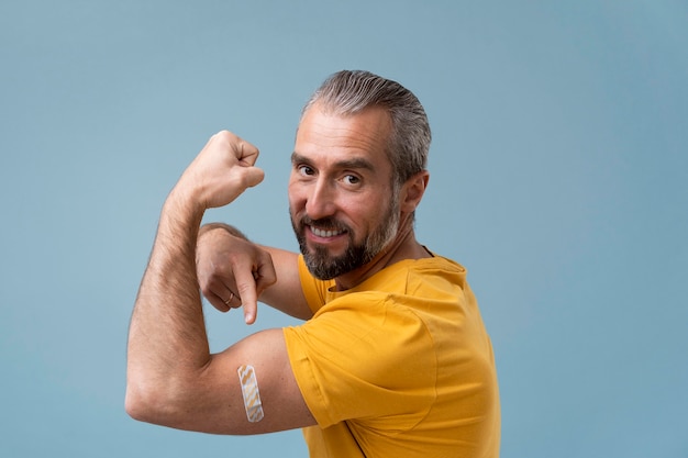 Free photo man with sticker on arm after getting a vaccine