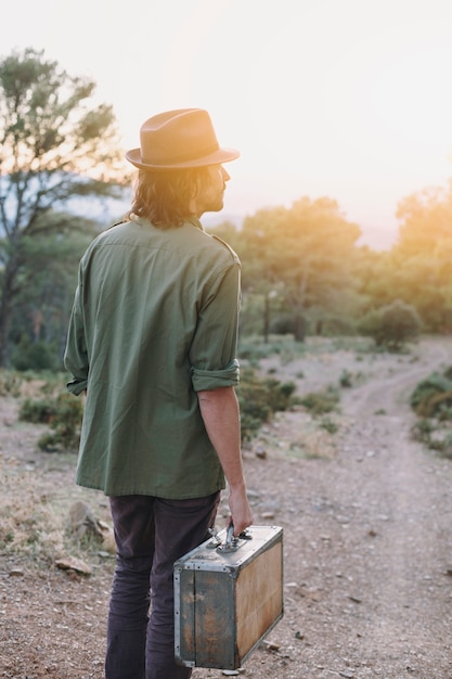 Free photo man with suitcase in nature