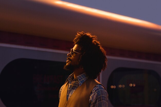 Man with sunglasses posing in retro style at night