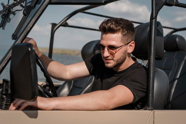 Man with sunglasses traveling alone by car