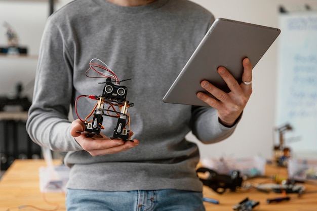 Man with tablet learning to make robot close up