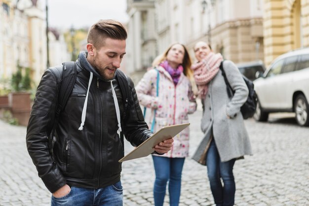 Man with tablet standing on street