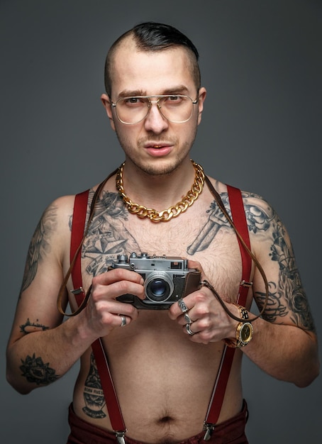 Free Photo man with tattoo holding photo camera. isolated on grey.