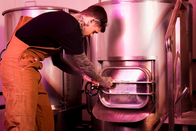 Free photo man with tattoos producing craft beer