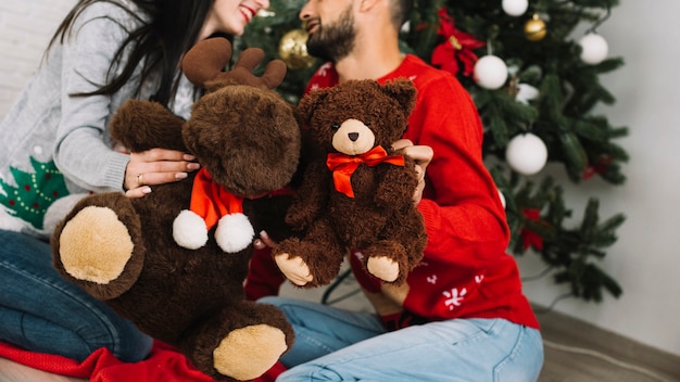 Man with teddy bear near woman with fluffy deer