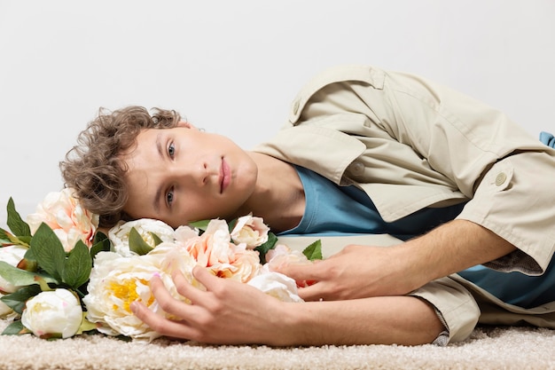 Man with trench coat holding flowers