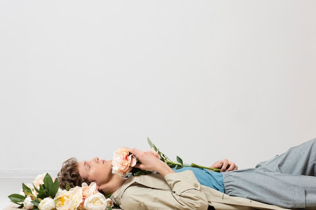 Man with trench coat holding flowers