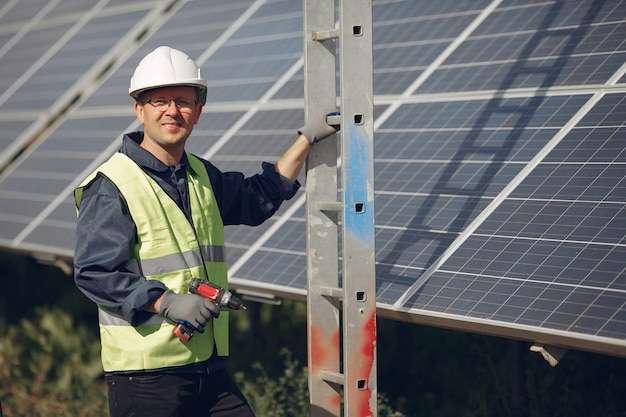 Man with white helmet near a solar panel