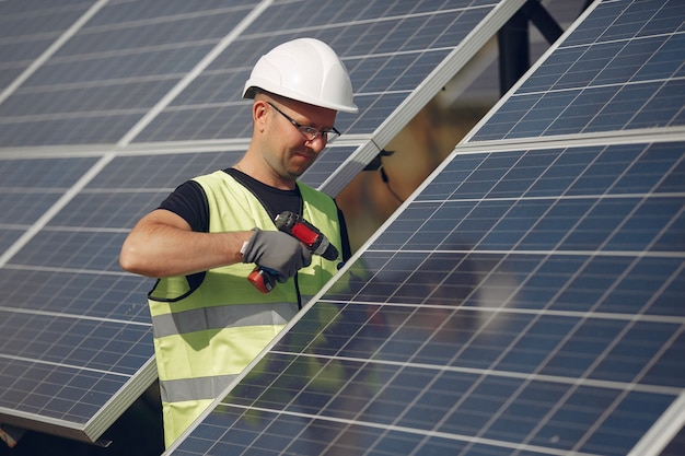 Man with white helmet near a solar panel