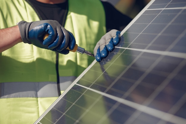 Man with white helmet near a solar panel