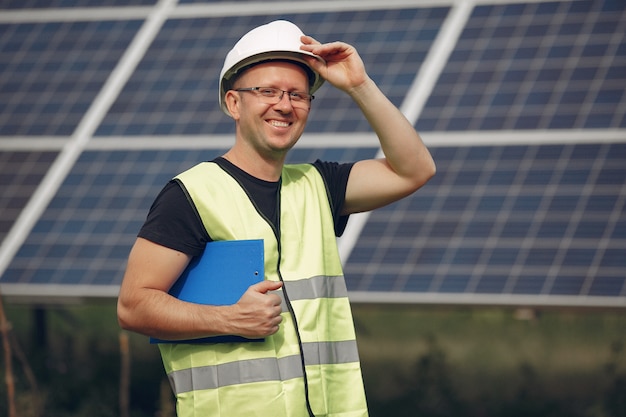 Man with white helmet near a solar panel