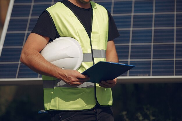 Man with white helmet near a solar panel