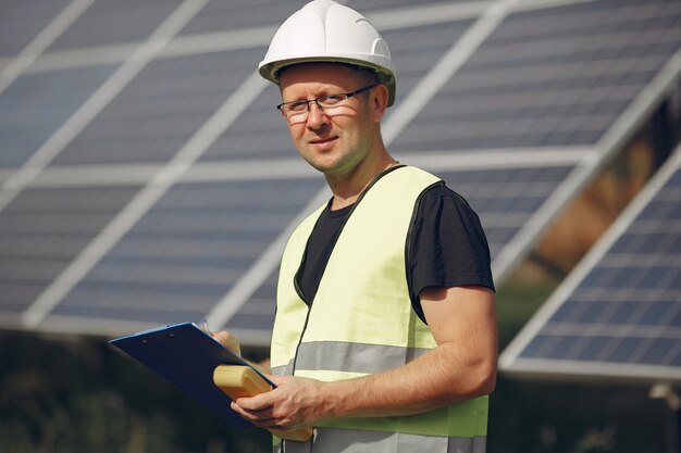 Man with white helmet near a solar panel