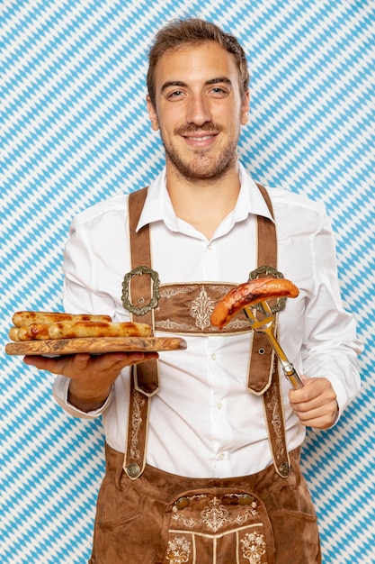 Man with wooden plate of german sausages