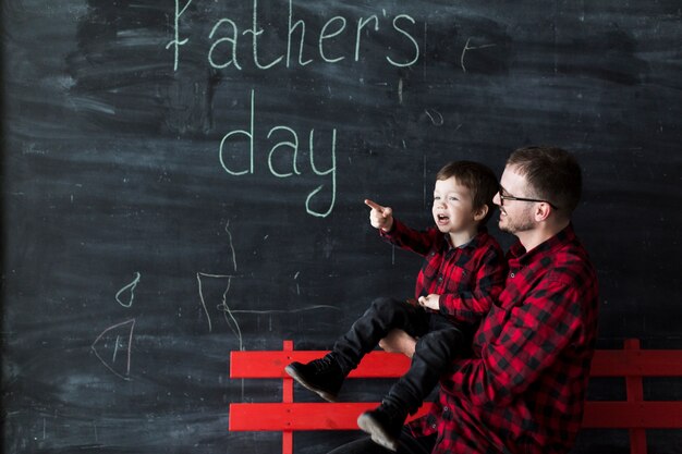 Man with young son on fathers day in front of chalkboard